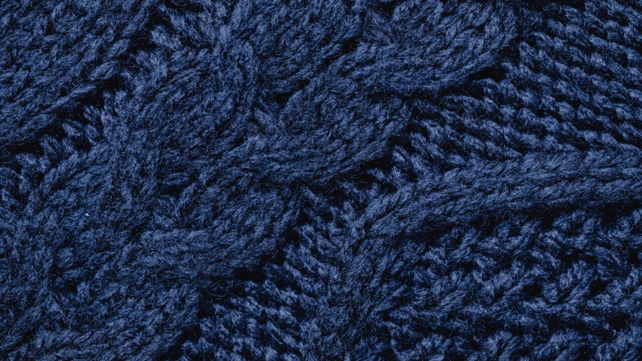 ネイビー〜コバルトブルーのケーブル編みニットをクローズアップした写真(Ader Errorのシグネチャーカラー「Z-Blue」の質感イメージ)