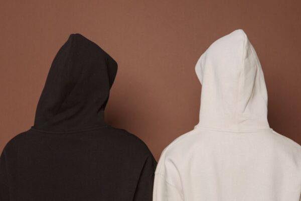 黒と生成りのオーバーサイズフーディを着た2人の後ろ姿。Fear of Godのくすんだトーンとオーバーサイズシルエットという世界観のイメージ