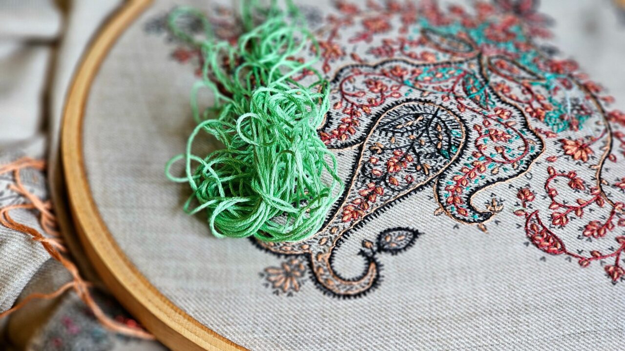 ペイズリー柄の手刺繍と刺繍糸の束のクローズアップ(Chopova Lowenaが軸に据えるブルガリア伝統刺繍・手仕事のイメージ)