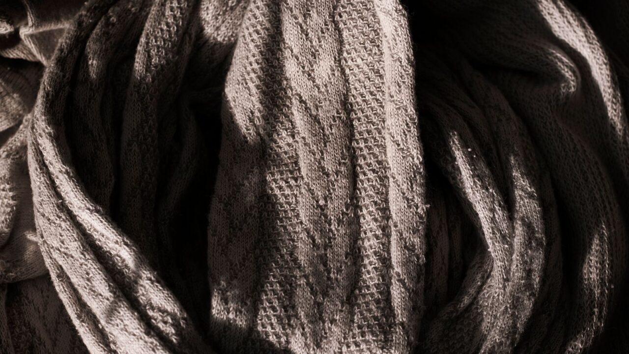 グレーのニット生地を接写した写真(Eckhaus Lattaの代名詞である編み込みニットウェアと、RISDでのテキスタイル専攻という背景のイメージ)