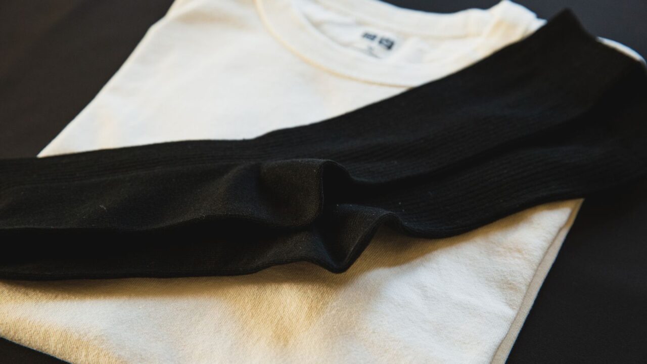 コム デ ギャルソン プレイの世界観 — 白Tシャツと黒ニットのフラットレイ