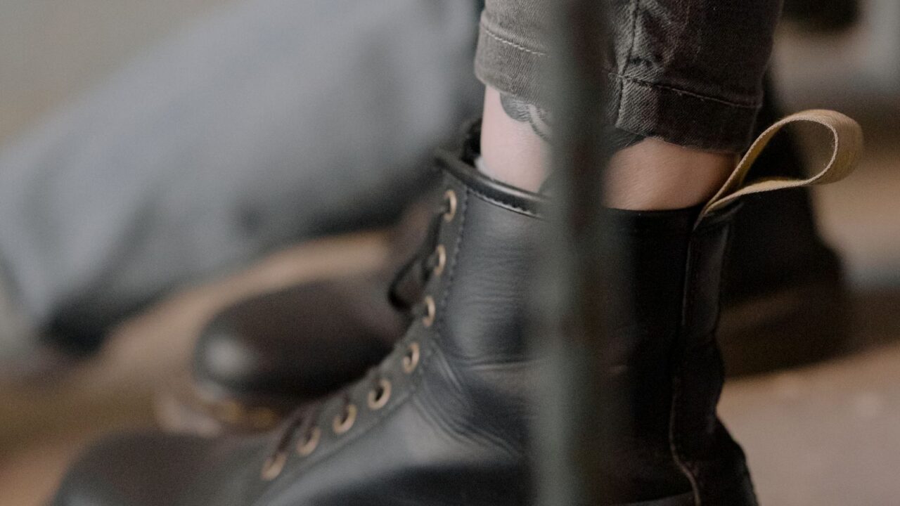 黒革のグランジブーツのクローズアップ写真(Dr. Martensのシグネチャーであるイエローステッチとヒールループのディテール。Heaven by Marc JacobsはDr. Martensと2021年から複数回コラボレーションしている)