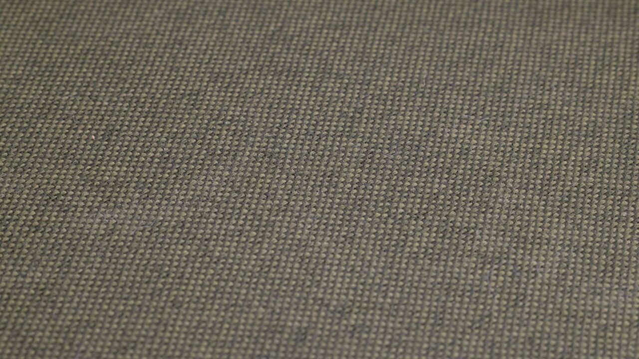 オリーブグリーンの織地のクローズアップ（Barbourのワックスドコットンのイメージ）