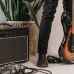 室内に置かれたベースアンプとベースギター（低音を支える機材の佇まいのイメージ）