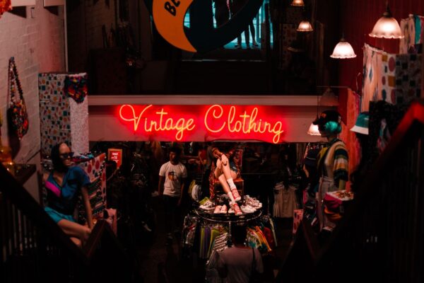 ネオンサインの「Vintage Clothing」が灯る古着店の店内を見下ろした風景