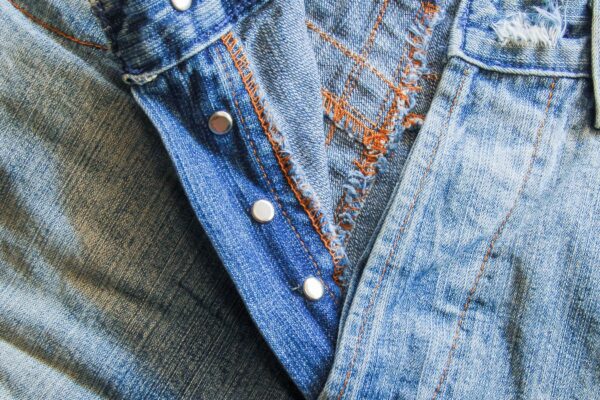 リベットと色落ちが残るブルーデニムのクローズアップ（Levi'sの銅リベット特許から続くジーンズの世界観イメージ）
