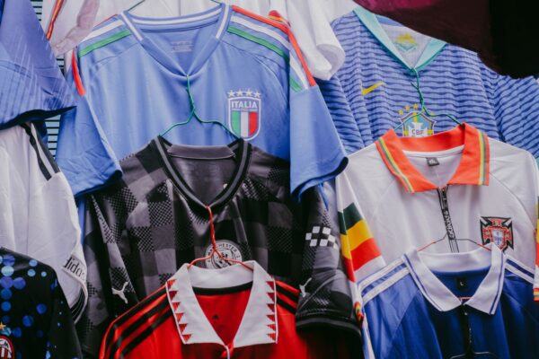 各国代表のヴィンテージサッカージャージがハンガーに並ぶカット(東京のヴィンテージスポーツウェア専門店ガイドのイメージ)